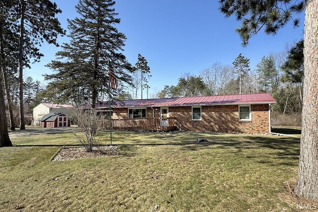 rear view of house with a deck, a lawn, and metal roof