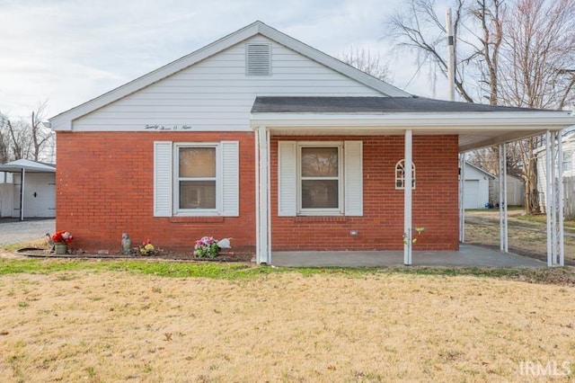 bungalow-style home with brick siding and a front yard