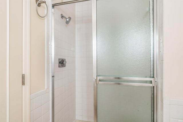 full bathroom with a shower stall and tile walls