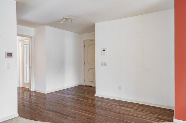 unfurnished room with wood finished floors and baseboards