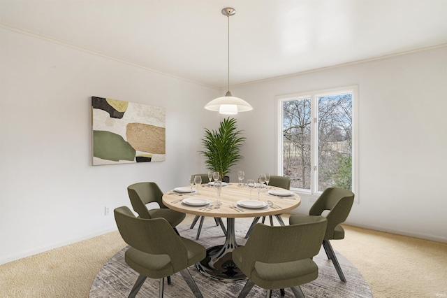 dining space with crown molding, baseboards, and carpet floors