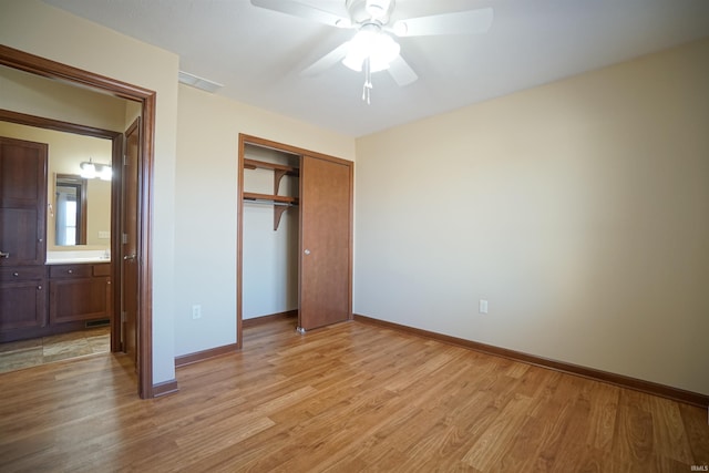 unfurnished bedroom featuring a closet, baseboards, visible vents, and light wood finished floors