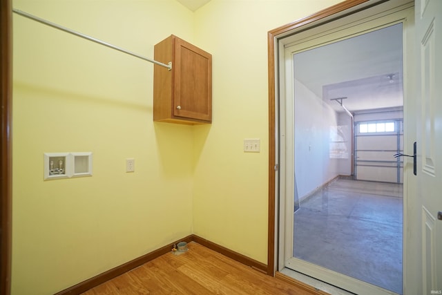 washroom featuring a garage, baseboards, hookup for a washing machine, and light wood finished floors