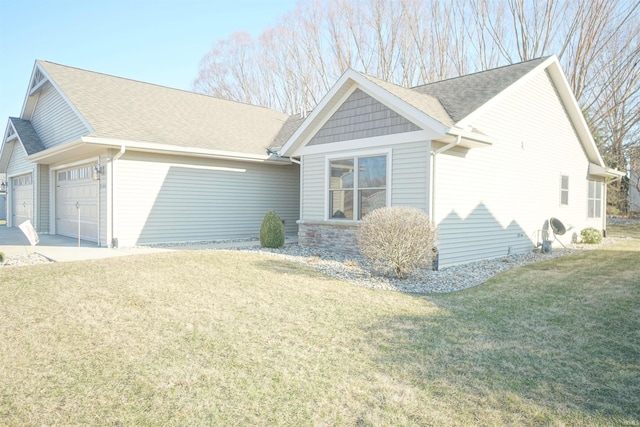 view of front of home with an attached garage, driveway, a front lawn, and roof with shingles