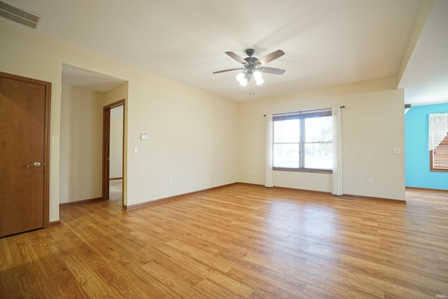 spare room with ceiling fan, visible vents, baseboards, and light wood-style flooring