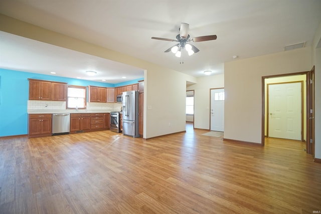 kitchen with visible vents, backsplash, stainless steel appliances, and light wood-type flooring