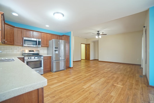 kitchen featuring tasteful backsplash, brown cabinets, appliances with stainless steel finishes, and light countertops