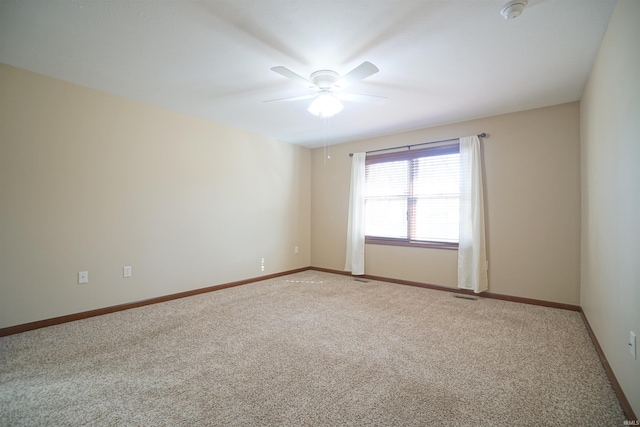 unfurnished room featuring a ceiling fan, visible vents, light colored carpet, and baseboards