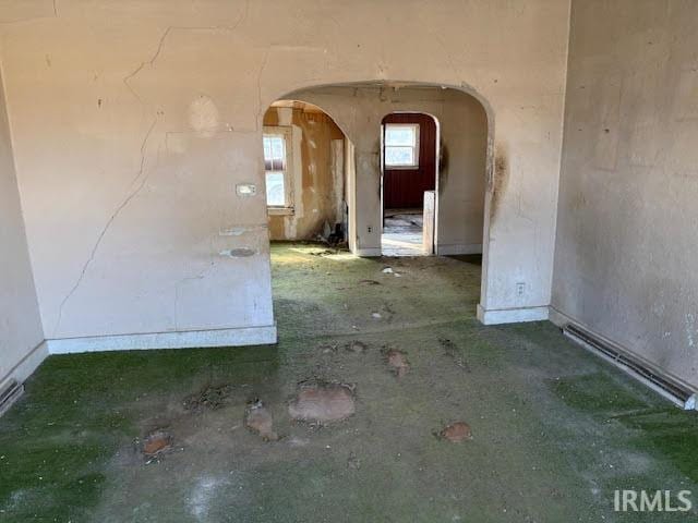 unfurnished room with arched walkways