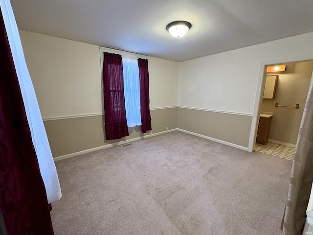 unfurnished bedroom featuring carpet, visible vents, and baseboards