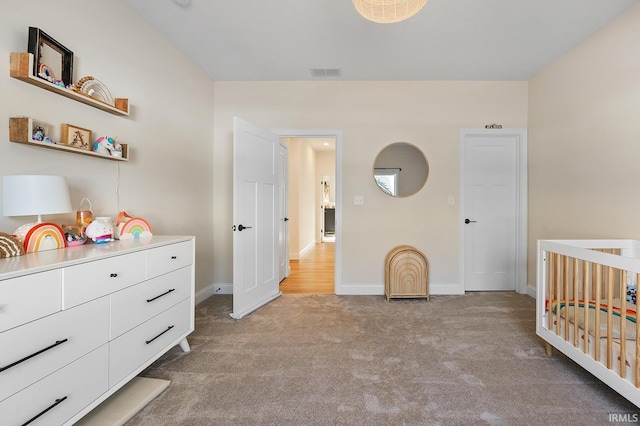 bedroom with a crib, light colored carpet, visible vents, and baseboards