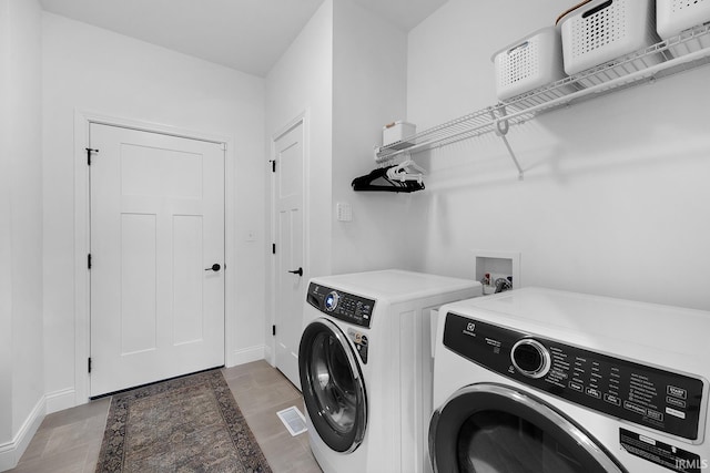 laundry area with laundry area, separate washer and dryer, and baseboards