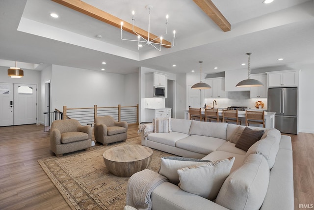 living room with recessed lighting, light wood-type flooring, and beam ceiling