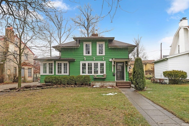 view of front of home with a front yard and a chimney