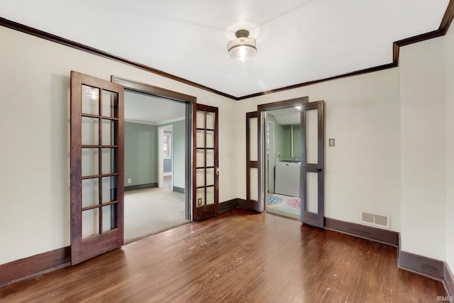 unfurnished room with visible vents, baseboards, french doors, wood finished floors, and washer / clothes dryer