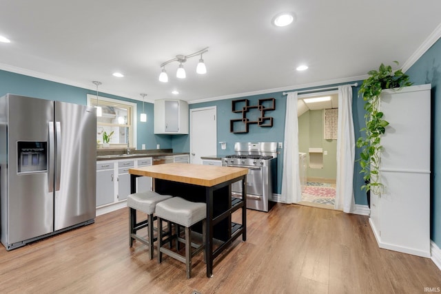 kitchen featuring light wood-type flooring, open shelves, wood counters, appliances with stainless steel finishes, and crown molding