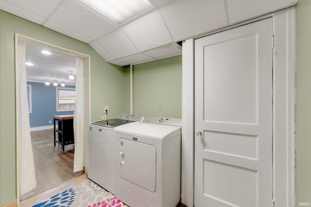 laundry room with light wood-type flooring, baseboards, independent washer and dryer, and laundry area