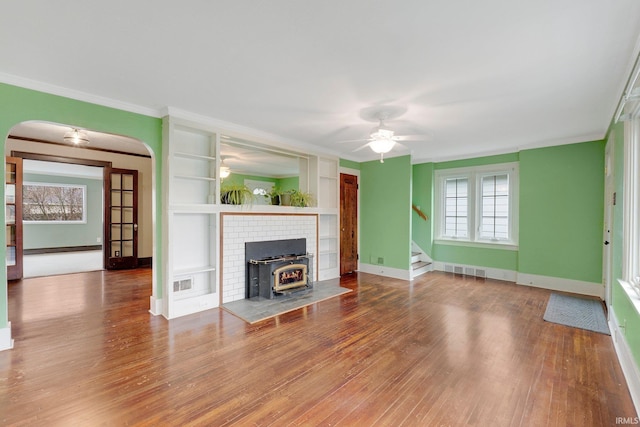 unfurnished living room featuring visible vents, ornamental molding, baseboards, and wood finished floors