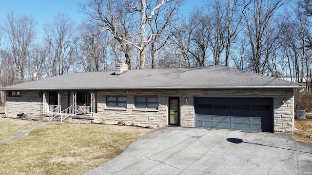 ranch-style home featuring a shingled roof, a chimney, a front lawn, stone siding, and aphalt driveway