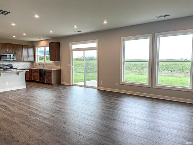 kitchen with tasteful backsplash, visible vents, dark wood-style flooring, and stainless steel appliances