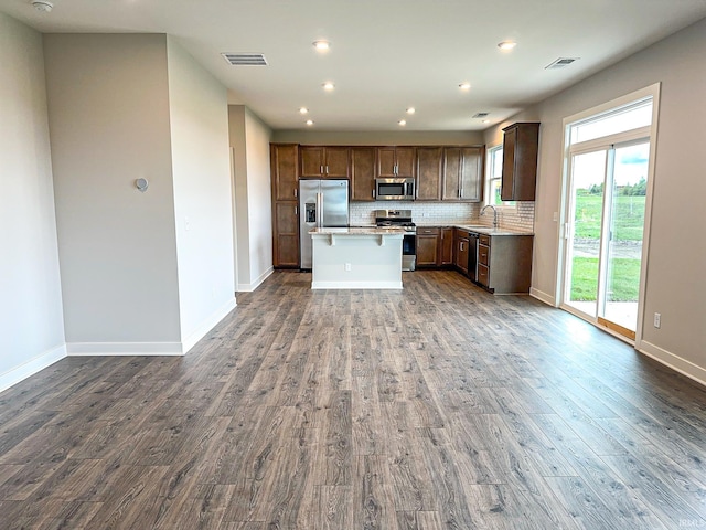 kitchen with dark wood-style flooring, visible vents, backsplash, and stainless steel appliances