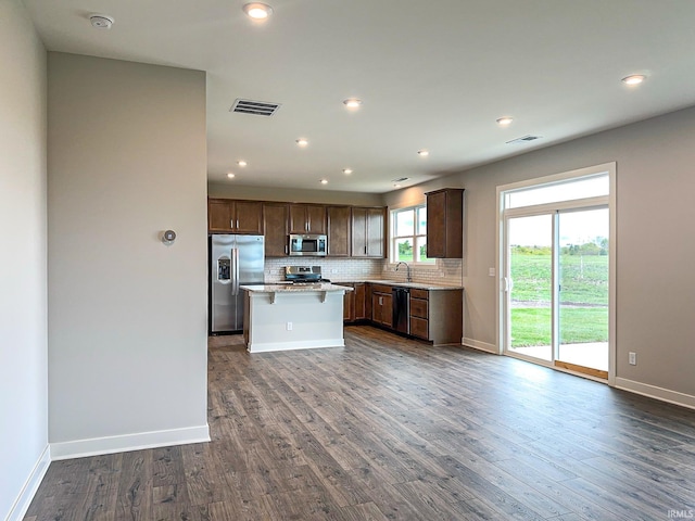 kitchen featuring a sink, decorative backsplash, dark wood-style floors, and stainless steel appliances