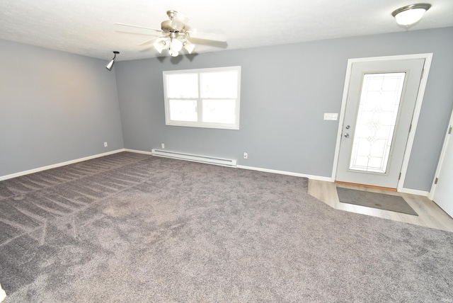 interior space featuring baseboard heating, baseboards, and a ceiling fan