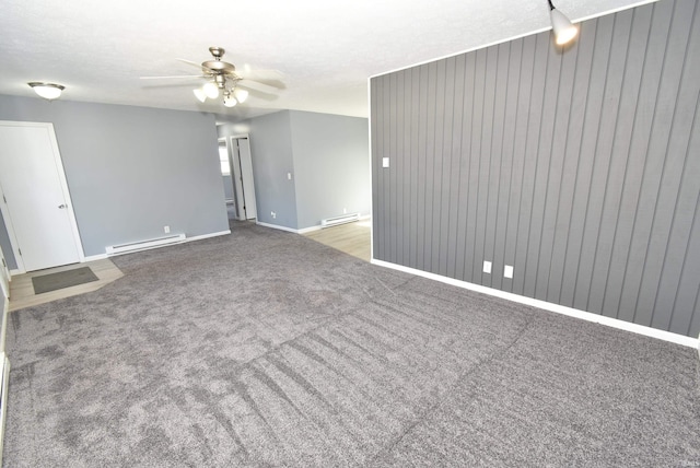 carpeted spare room with baseboard heating, baseboards, and a ceiling fan