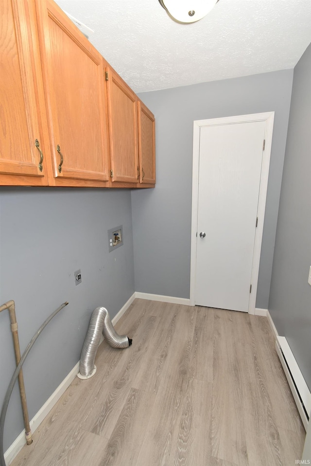 washroom featuring baseboard heating, cabinet space, baseboards, and light wood-style floors