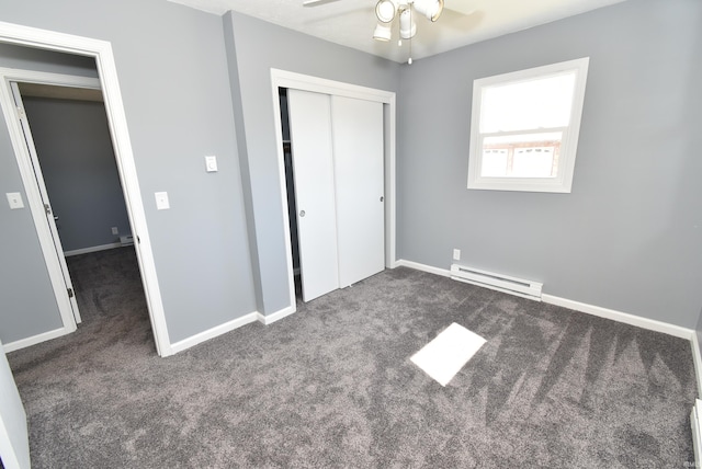 unfurnished bedroom featuring a closet, baseboard heating, baseboards, and carpet