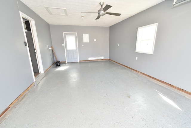 empty room with attic access, a ceiling fan, speckled floor, and a textured ceiling