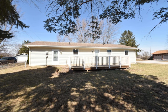 back of property with a deck, a yard, and fence