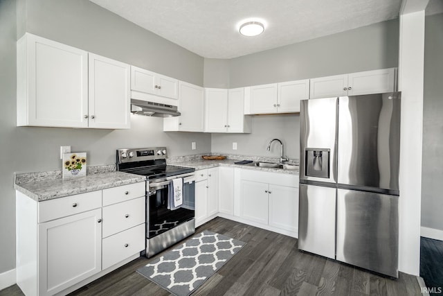 kitchen featuring under cabinet range hood, white cabinetry, appliances with stainless steel finishes, and a sink