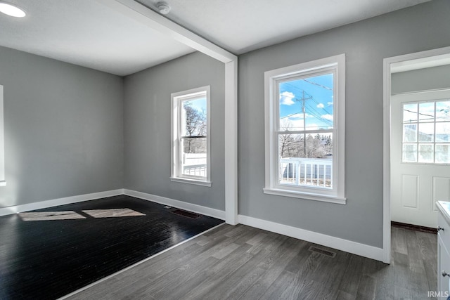 interior space featuring visible vents, baseboards, and dark wood-style flooring