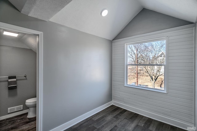 interior space featuring a wealth of natural light, visible vents, lofted ceiling, and wood finished floors