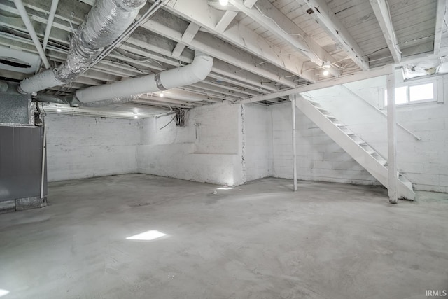 basement featuring heating unit and stairway