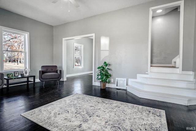 sitting room featuring visible vents, a ceiling fan, dark wood-type flooring, and baseboards