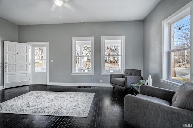 foyer entrance with dark wood finished floors, plenty of natural light, baseboards, and visible vents