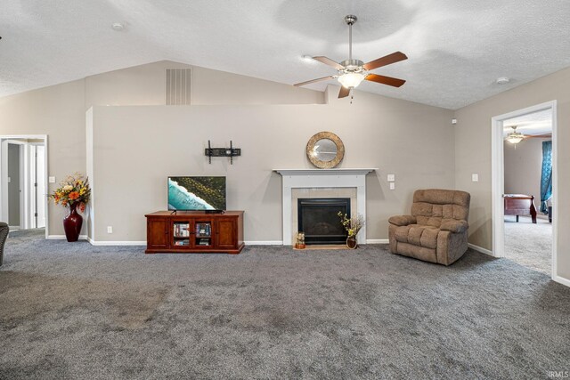 carpeted living room with visible vents, lofted ceiling, ceiling fan, a textured ceiling, and a tiled fireplace