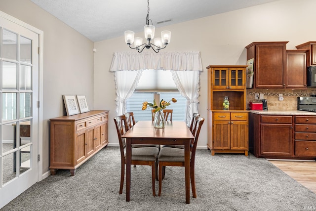 dining space featuring vaulted ceiling, a notable chandelier, baseboards, and visible vents