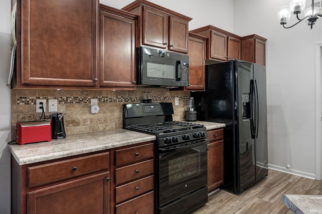 kitchen with tasteful backsplash, light wood-style flooring, black appliances, and light countertops