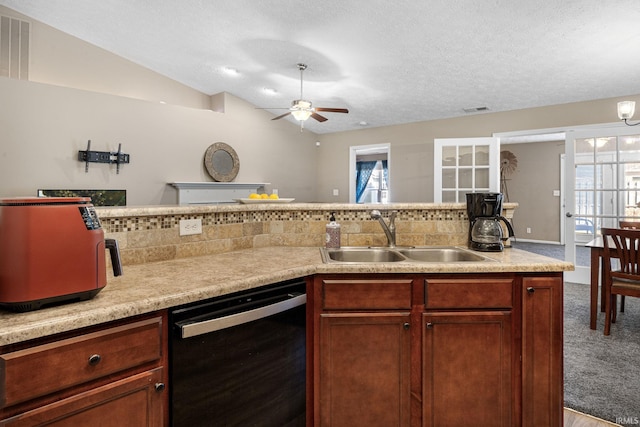 kitchen with visible vents, a sink, light countertops, dishwasher, and vaulted ceiling