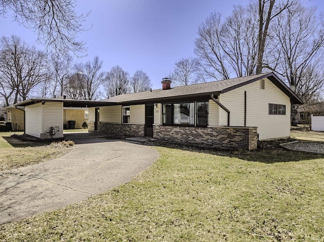 view of front of property featuring a carport, a chimney, concrete driveway, and a front yard