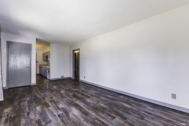 unfurnished living room with dark wood finished floors and baseboards