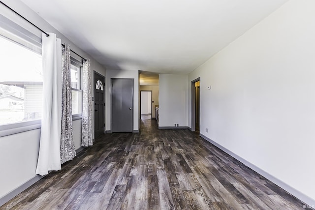 interior space featuring baseboards and dark wood-style floors