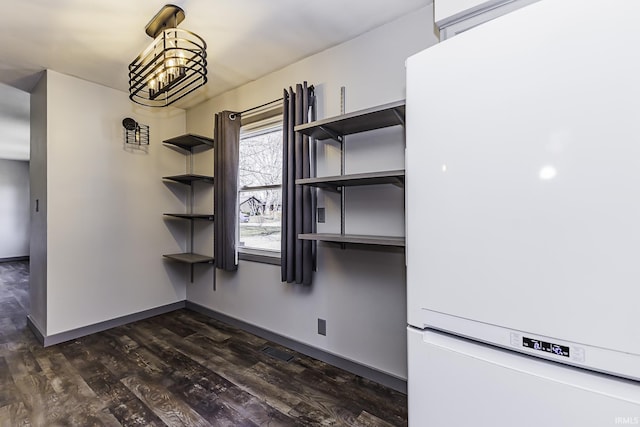 unfurnished dining area with visible vents, baseboards, dark wood-type flooring, and a chandelier