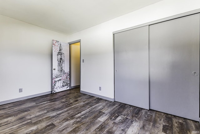 unfurnished bedroom featuring a closet, baseboards, and wood finished floors