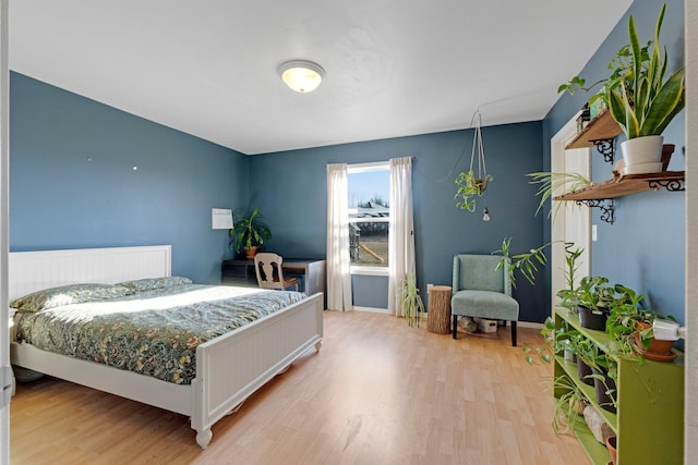 bedroom featuring baseboards and light wood finished floors