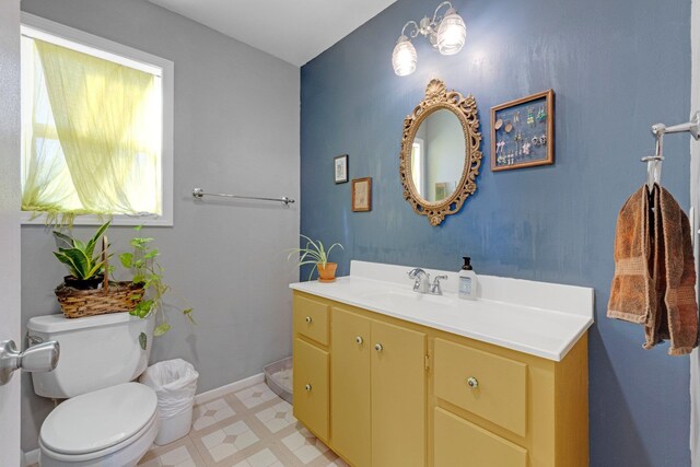 half bathroom featuring vanity, tile patterned floors, toilet, and baseboards