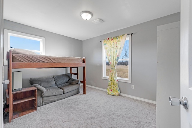 carpeted bedroom featuring baseboards and multiple windows